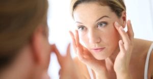 Woman looking her reflection in a mirror