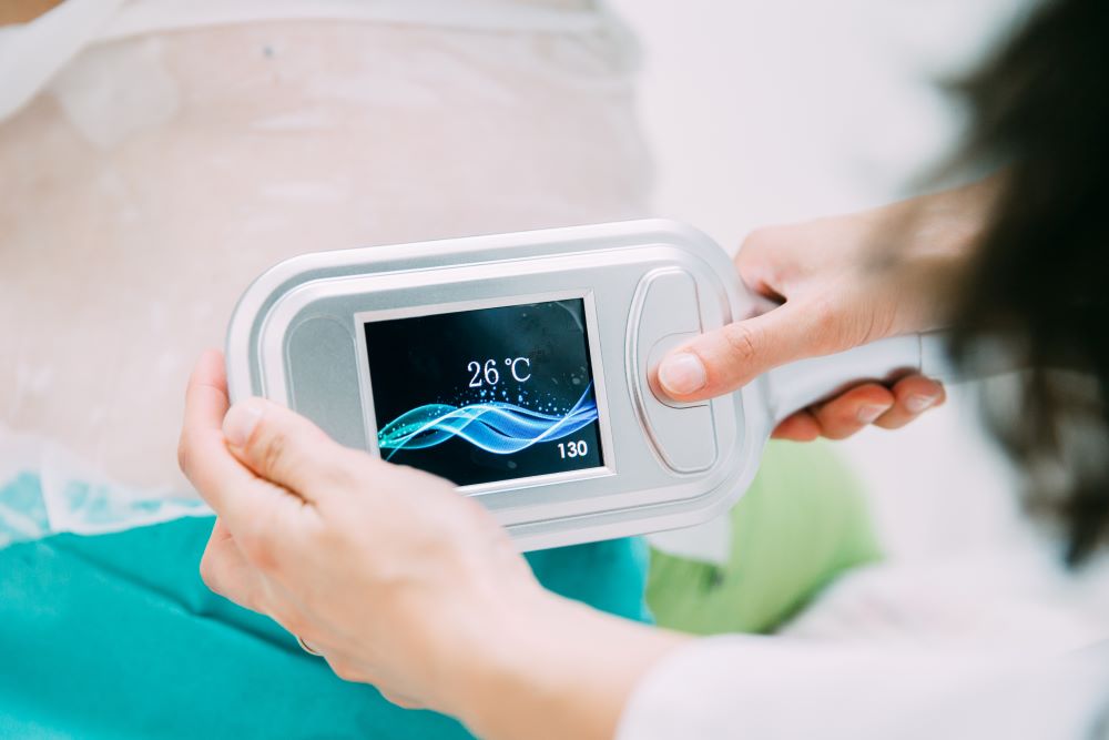 CoolSculptingHistoryYLSC A practitioner holding up a CoolSculpting device to view how cold the device settings are.