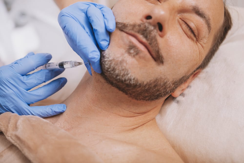 Bearded handsome mature man getting anti-wrinkle treatment