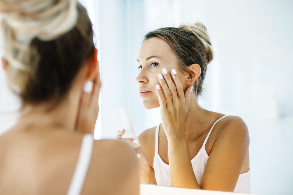 How Many IPL Treatments Should I Get to See the Best Results Woman looking at face in the mirror considering an IPL photofacial