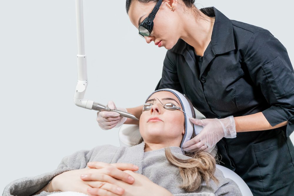 IPL Photofacials: What to Expect Beauty laser technician performing a cosmetic skin resurfacing session on a female patient, also called a photofacial