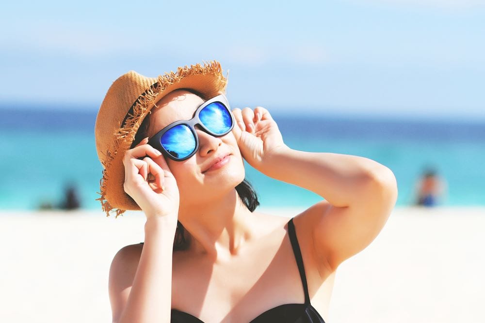 summer-acne Woman on a beach wearing sunglass