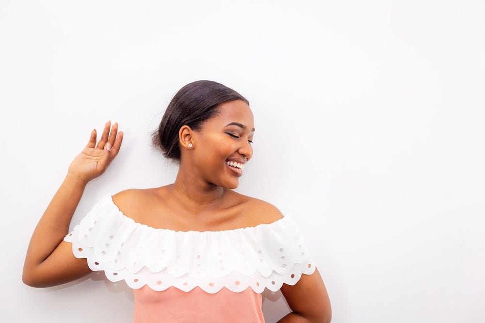 what-coolsculpting-feel-like Woman smiling while leaning on wall